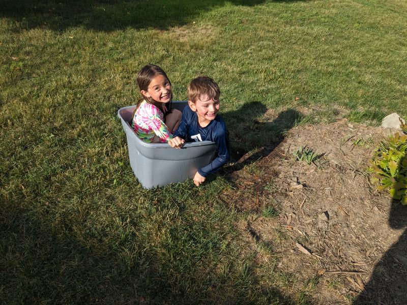 Ben and Astrid sitting in the water squirter refill station